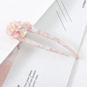 Detailed close-up of the delicate floral acetate U-shaped hair fork in sweet pink.