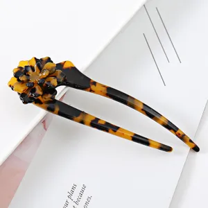 Close up detail of tortoiseshell acetate U shaped flower hair fork for stylish updo hairstyles.