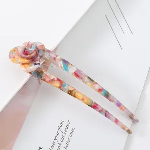Detail shot of colorful acetate U-shaped hair stick with floral design, elegant hair accessory.