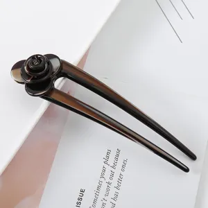Closeup detail view showing the exquisite texture and 3D floral carving of the acetate hair stick.