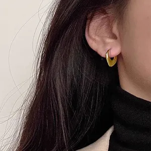 Vue de détail de boucles d'oreilles créoles dorées géométriques minimalistes chic.