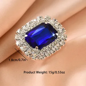 Luxury rectangular blue crystal rhinestone ring detail shot, sparkling claw chain design.