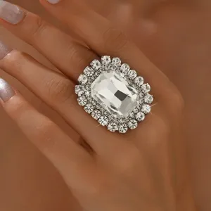 Close-up of a glamorous luxury rectangular crystal cocktail ring with sparkling rhinestone halo.