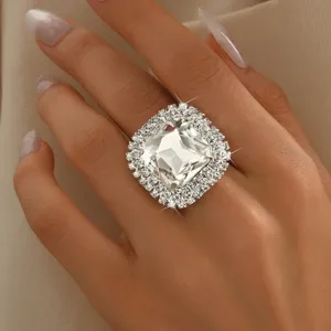 Primo piano dettagliato di un anello geometrico in strass scintillante sulla mano.