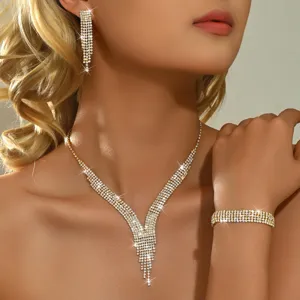 Close-up detail van de sprankelende strass kwast ketting en bijpassende armband set op model.