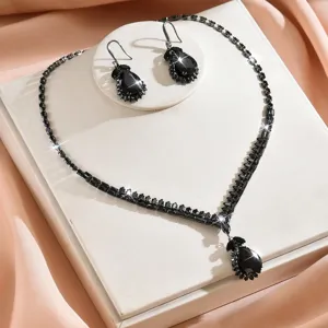 Dettaglio in primo piano di collana e orecchini in zircone nero su espositore.