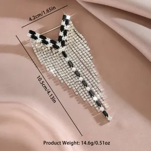 Primo piano di una spilla con nappe in strass scintillanti con cristalli neri.