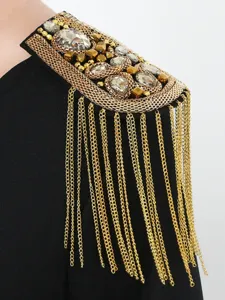 Primo piano dettaglio della spallina con catena dorata strass stile punk retro.