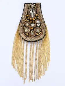Vista dettagliata della spallina con nappe metalliche in stile punk vintage con cristalli.