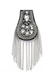 Dettaglio ravvicinato della spallina con strass e catena in stile punk vintage.