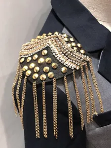 Close-up of a handmade rivet tassel shoulder epaulet with sparkling rhinestones and gold chains.