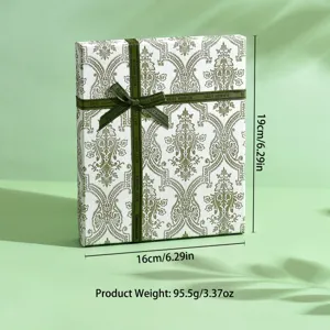 Elegante confezione regalo bianca con motivo damascato verde e nastro per gioielli.