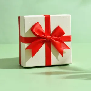 Squisita confezione regalo quadrata con coperchio bianco e nastro rosso per gioielli.