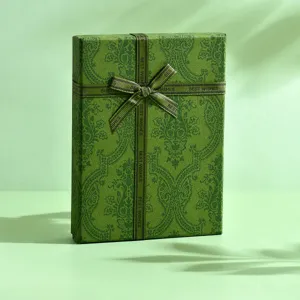Vista dettagliata dell'elegante confezione regalo verde con motivo damascato e nastro.