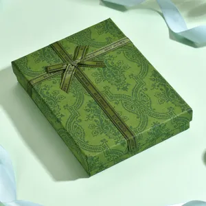 Dettaglio di scatola regalo verde con motivo paisley vintage e bel nastro per confezione di gioielli.