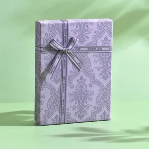 Scatola regalo viola con nastro e fiocco, dettaglio di imballaggio per gioielli.