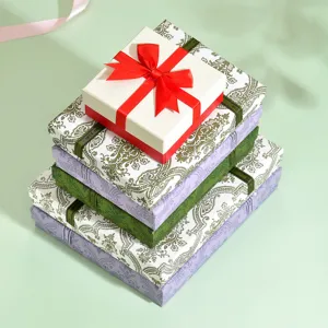 Primo piano di eleganti scatole regalo decorative impilate con nastri e motivi vintage.