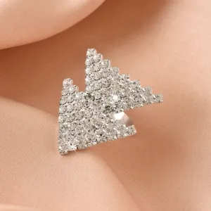 Vista dettagliata di un anello aperto geometrico in strass con cristalli scintillanti.