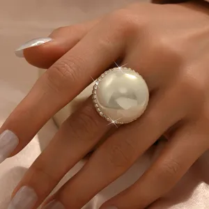 Vista dettagliata di un anello di perle grandi in stile europeo decorato con strass scintillanti.