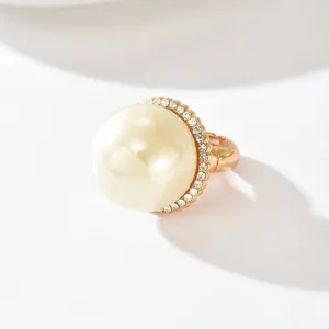 Anello aperto elegante con grande perla e luminoso alone di strass in tonalità oro.