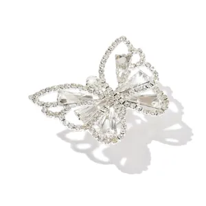 Primo piano di un anello a farfalla scintillante con strass luminosi e fascia argentata.