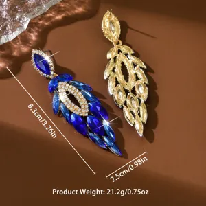 Gros plan détaillé des belles boucles d'oreilles pendantes en cristal bleu avec strass.