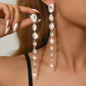 Gros plan détaillé de longues boucles d'oreilles pendantes en cristal étincelant sur modèle.