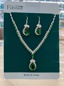 Vista dettagliata del set di collana e orecchini in zircone verde a pera, gioielli scintillanti.