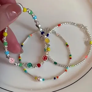 Rainbow smiley face beaded bracelet set, silver beads and pearls, sweet stackable jewelry detail.