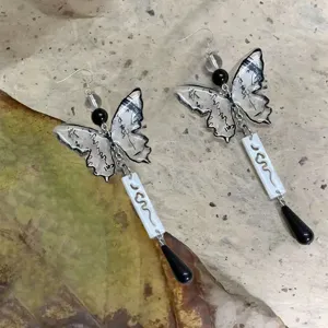 Close-up of Chinese style ink butterfly dangle earrings with chic droplets and delicate textures.