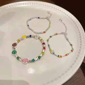 Detailed close-up shot of colorful rainbow smiley face beaded bracelets stacked together.