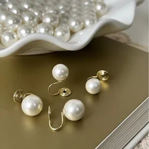Gros plan détaillé de boucles d'oreilles clips spirales dorées élégantes sans perçage.