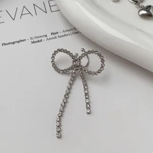 Silver rhinestone bow ear clip detail shot, elegant niche design fashion jewelry piece.