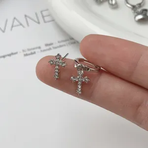 Silver zircon cross earrings detail shot, minimalist sparkling jewelry accessories for women.