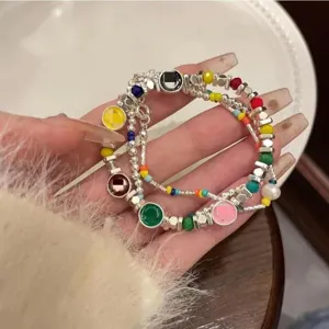 Layered silver beaded bracelet featuring colorful rainbow charms and sweet smiley face design.