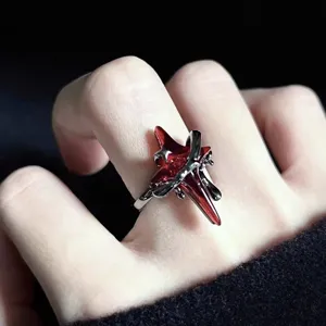 Detalle de anillo de estrella roja gótico, anillo abierto ajustable estilo punk oscuro.