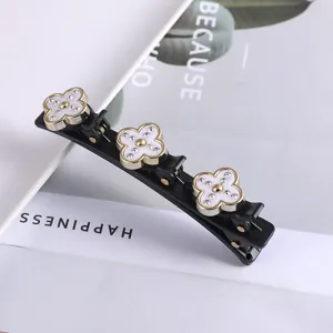 Detailopname van de dubbele strass klaverblad haarspeld met een eten elegant bloemenontwerp.