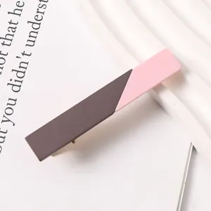 Close-up of a stylish two-tone resin duckbill hair clip, brown and pink color block design.