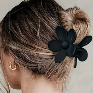 Détail de pince à cheveux fleur noire mate, design floral élégant pour une coiffure sûre.
