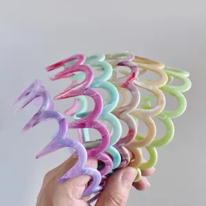Primer plano detalle diadema resina zigzag colorida, cinta ondulada estilo uso diario.