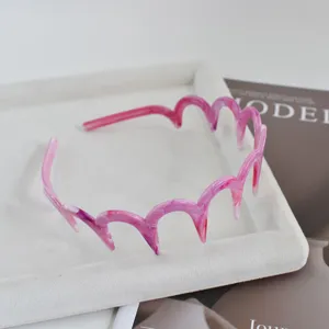 Primer plano detallado de una diadema ondulada jaspeada rosa, elegante accesorio pelo.