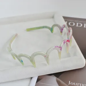 Vista detallada de la diadema ondulada con diseño de nubes y dientes, accesorio muy elegante.