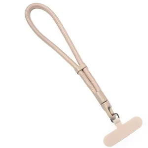 Gros plan sur les details de la dragonne de telephone beige avec boucle reglable.