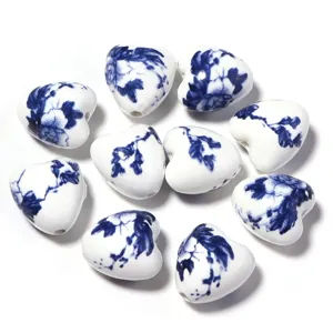 Gros plan de perles en céramique cœur en porcelaine bleue et blanche pour le bricolage de bijoux.