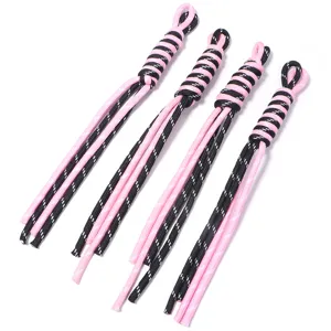 Closeup of handmade woven lanyard keychain detail, pink and black braided nylon cord accessory.