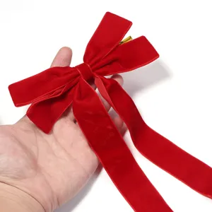 Rote Samtschleife Nahaufnahme mit langem Band und Golddraht, ideal für elegante Geschenkverpackung.