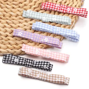 Detailed close-up of colorful gingham bow hair clips with cute floral prints, perfect for DIY.