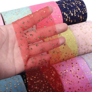 Detail shot of colorful tulle fabric rolls with gold foil star prints for DIY crafts and decor.