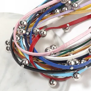 Detail shot of punk style colorful leather cord choker with silver metal beads accessory.