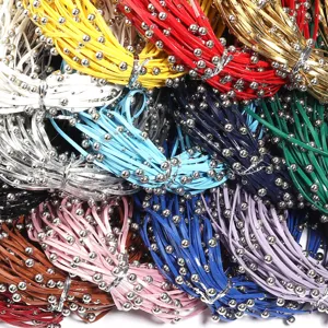 Detailed close-up of colorful leather cord straps with metallic beads, DIY jewelry making.